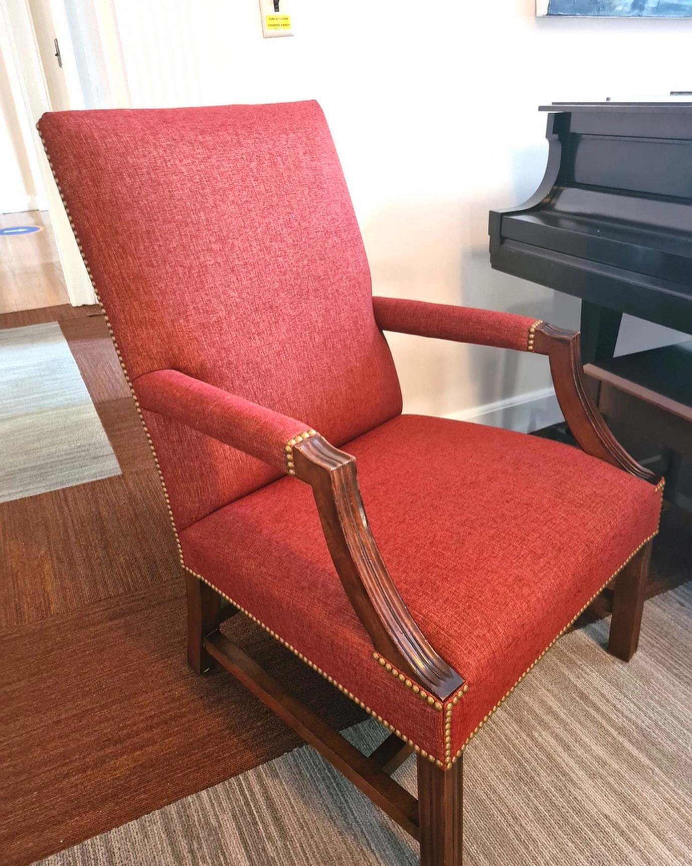 Armchair reupholstered by Melmar in red woven fabric with nailhead trim