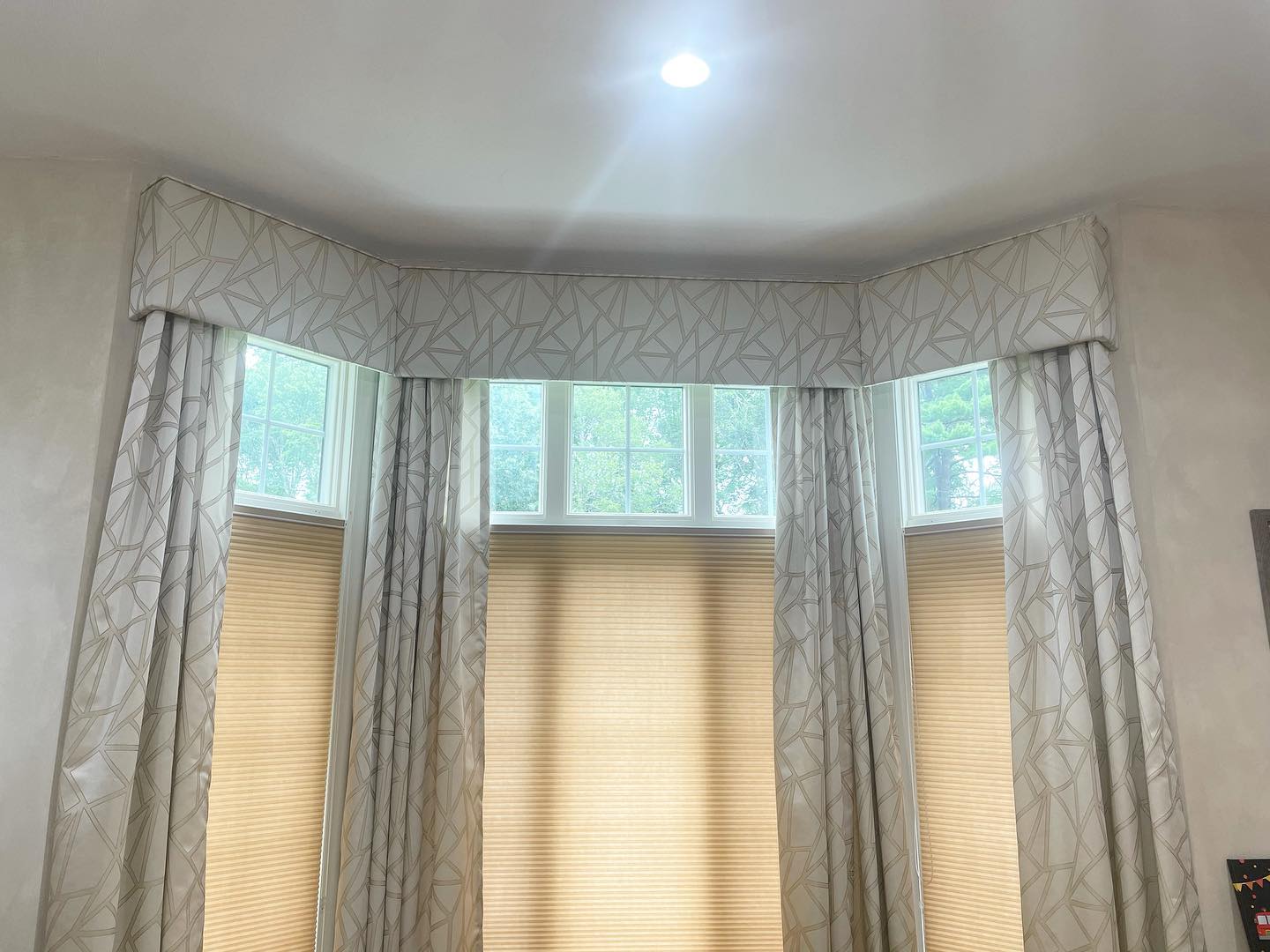 Custom upholstered cornice and drapery over a residential bay window by Melmar